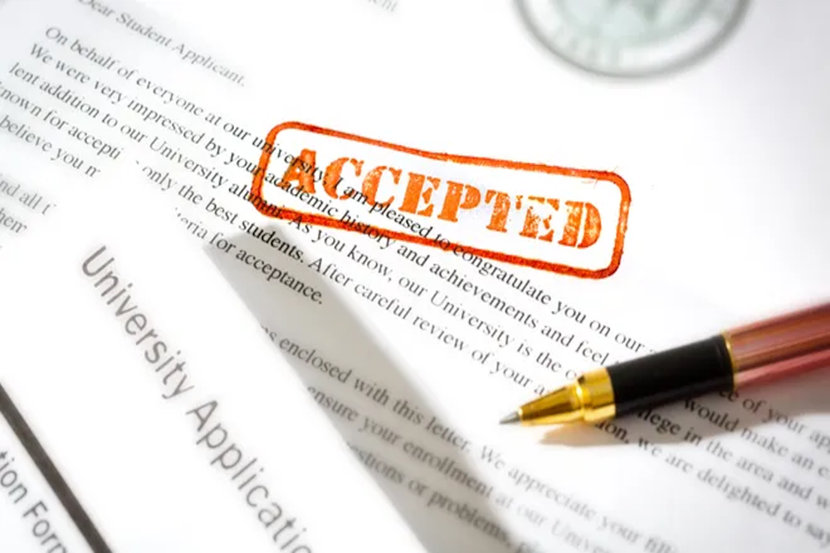 Pen over a college application stamped Accepted
