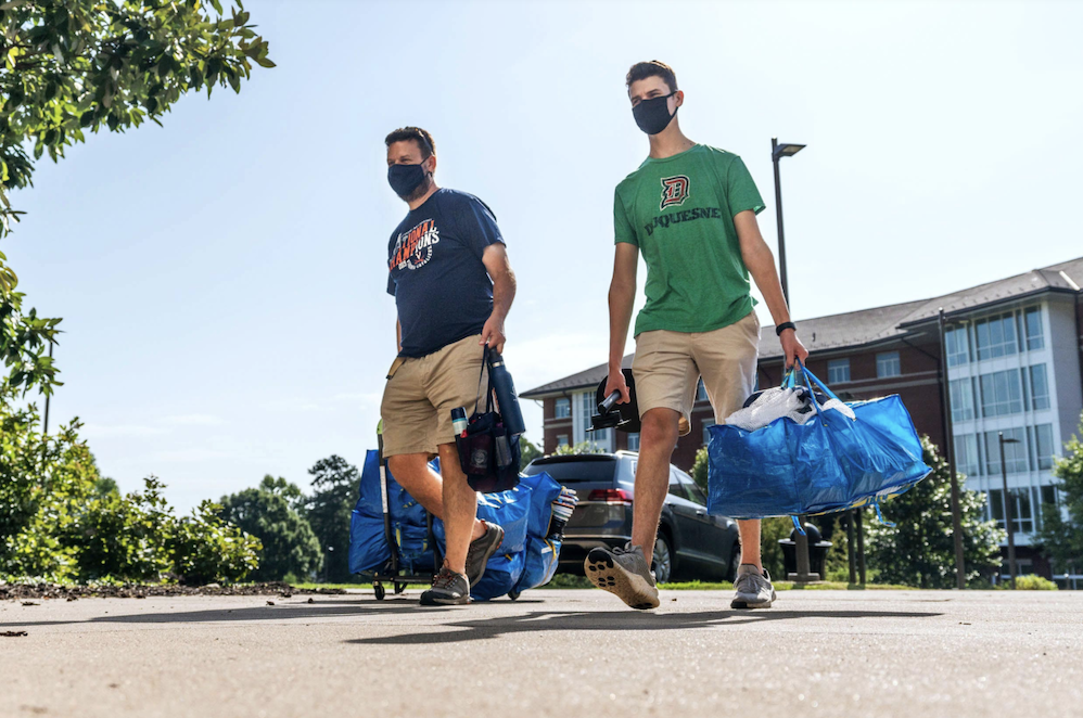 A father and son carry bags into UVAâs dorms during move-in day last year. (Photo by Sanjay Suchak, University Communications)