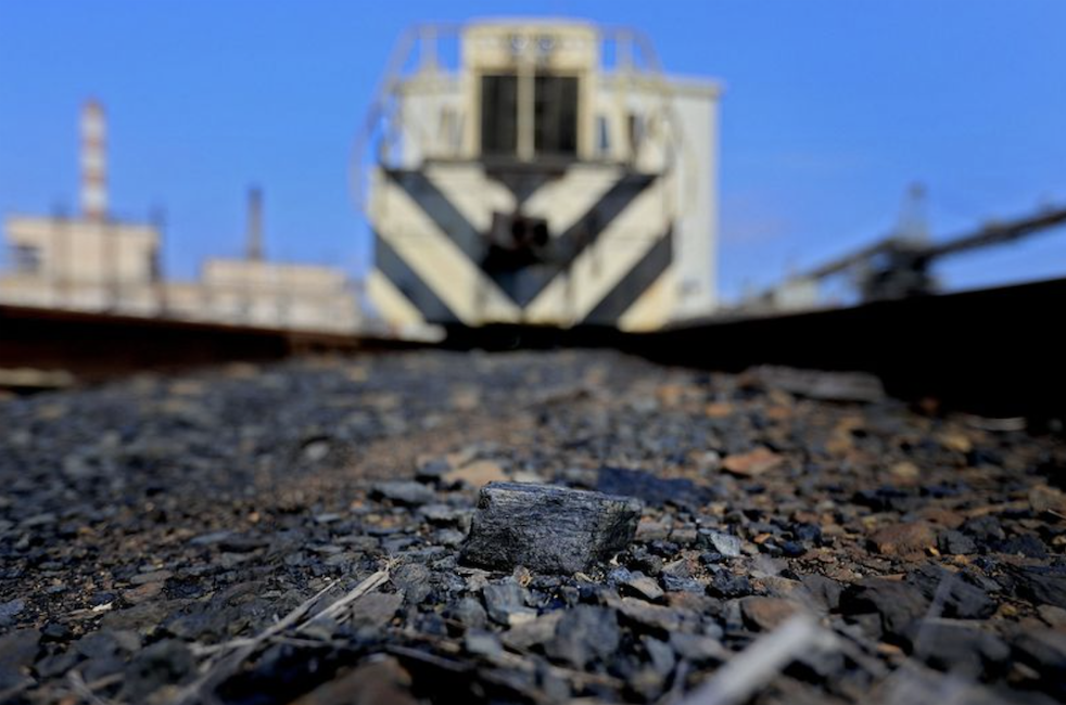 A lump of coal sits between the railroad tracks where for decades it was delivered to generate electricity at the Yorktown Power station, where two coal powered steam turbines were shut down in 2019. (Rob Ostermaier)