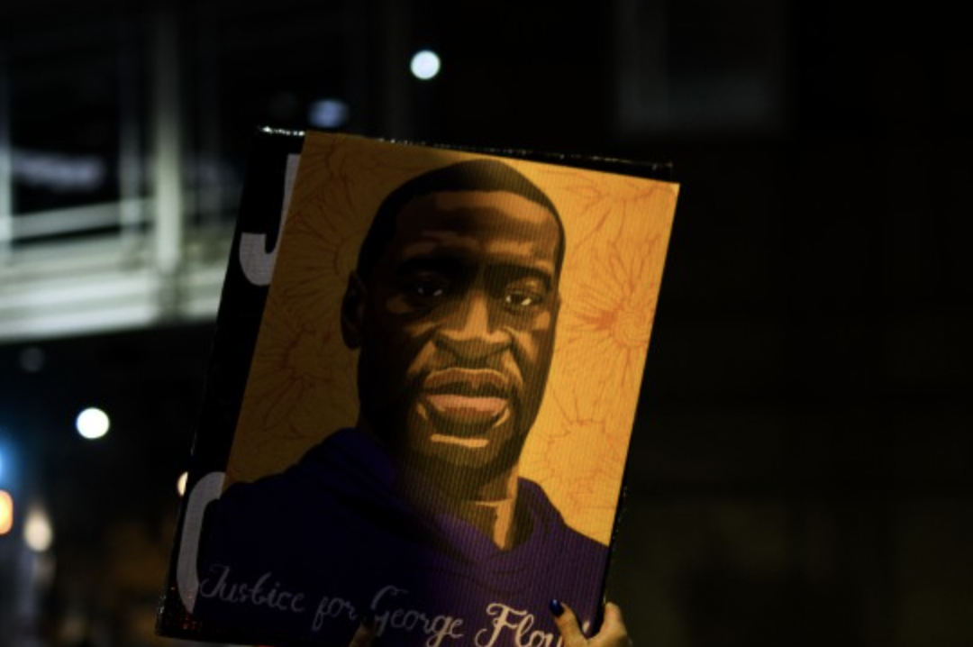 A woman holds up a portrait of George Floyd as people gather outside the Hennepin County Government Center on April 9, 2021 in Minneapolis, Minnesota, where the trial of former Minneapolis police officer Derek Chauvin is taking place.